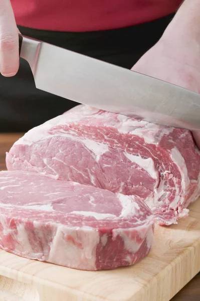 Hombre Rebanando carne cruda —  Fotos de Stock