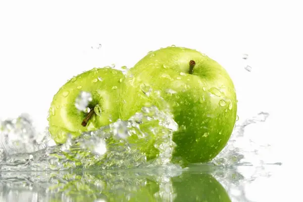 Dua apel hijau dengan percikan air — Stok Foto
