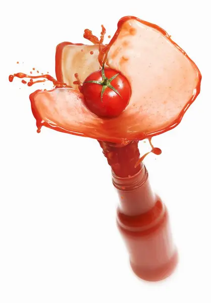 Jugo de tomate salpicando fuera de la botella — Foto de Stock