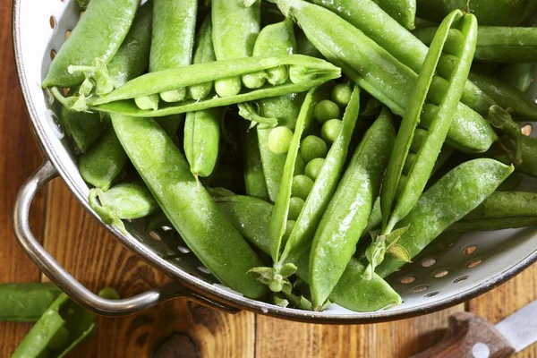 Frische grüne Erbsen im Sieb — Stockfoto