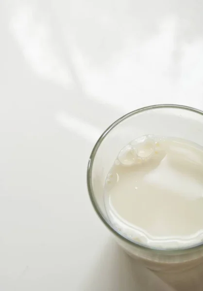 Glas Milch auf weißer Oberfläche — Stockfoto