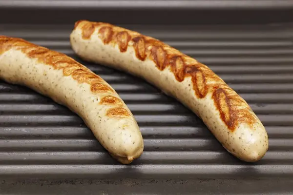 White sausages on a grill — Stock Photo, Image