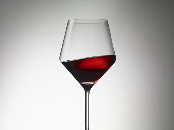 Red wine sloshing in a wine glass — Stock Photo, Image