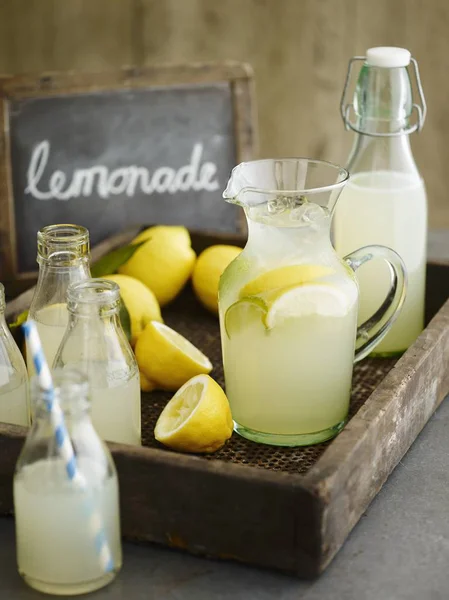 Lemonade in bottles and jug — Stock Photo, Image