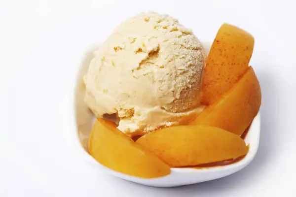 Apricot ice cream garnished with apricot wedges — Stock Photo, Image