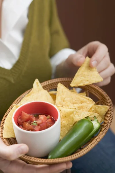 Žena hospodářství koš nachos — Stock fotografie