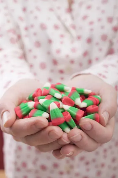 Female hands holding candy corn — Stock Photo, Image