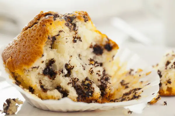Half-gegeten chocolade chip muffin — Stockfoto