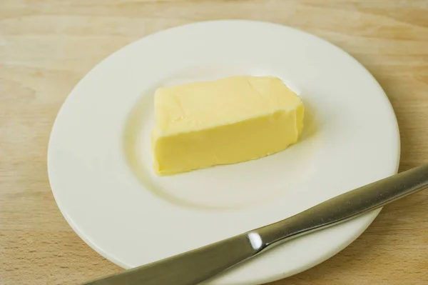 Vue Rapprochée Une Natte Beurre Sur Une Assiette Avec Couteau — Photo