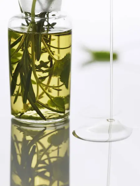 Herbal Oil Bottle Flowing Reflective Surface — Stock Photo, Image