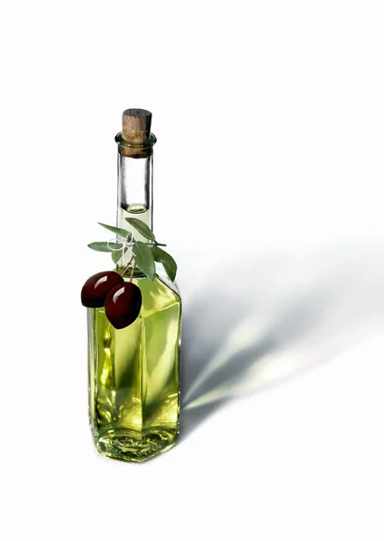 Olive oil bottle with black olives — Stock Photo, Image