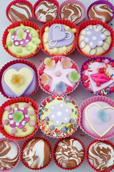 Cupcakes em coberturas de bolo de plástico vermelho e rosa — Fotografia de Stock