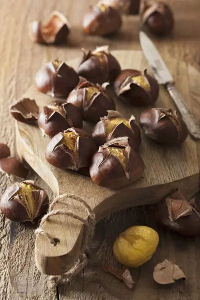 Chestnuts on wooden chopping board — Stock Photo, Image