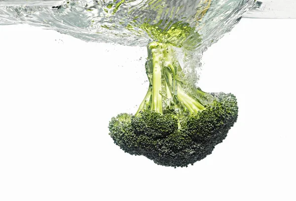 Broccoli falling into water — Stock Photo, Image