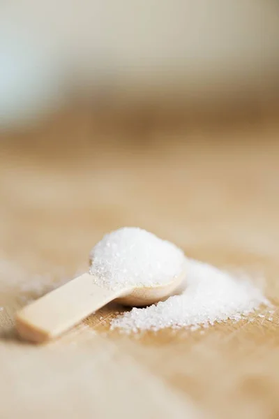 Granulated sugar on wooden spoon — Stock Photo, Image