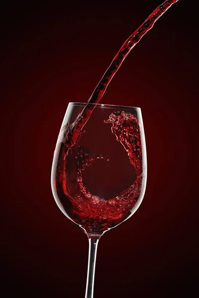 Red wine pouring into glass — Stock Photo, Image