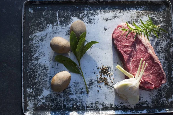 Raw Beef steak with garlic and potatoes — Stock Photo, Image