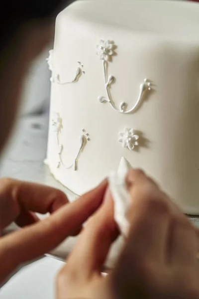 Konditorn dekorerar en bröllopstårta — Stockfoto