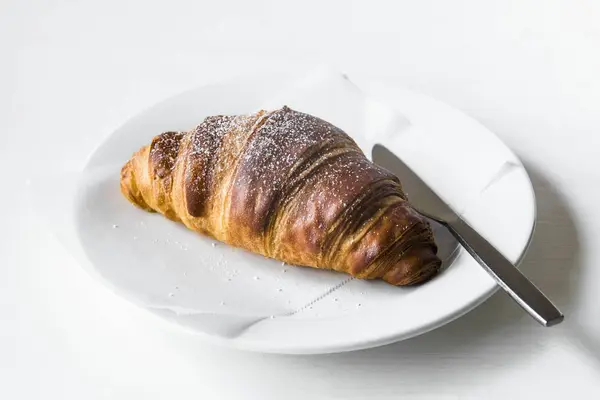 Croissant on a white plate — Stock Photo, Image