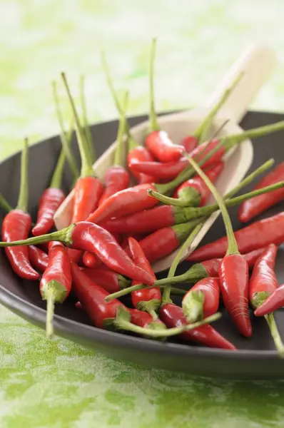 Κόκκινες πιπεριές τσίλι σε μαύρο πιάτο — Φωτογραφία Αρχείου