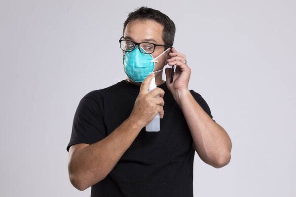 Страшный человек дезинфицирует свой телефон, разговаривая с кем-то
.