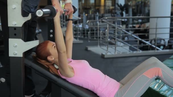Young Woman Doing Barbell Bench Press Under Trainer Supervision In