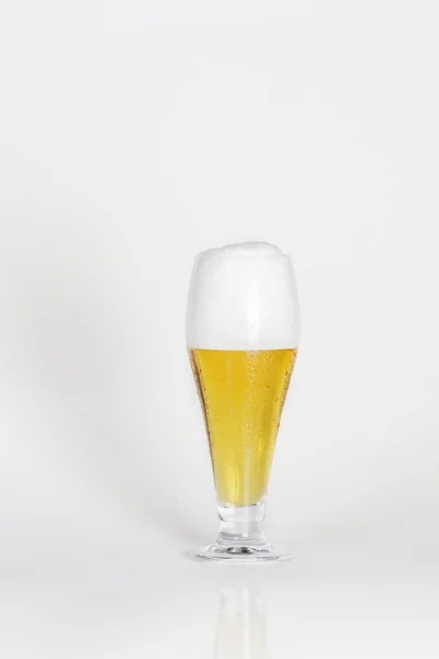 Vaso de cerveza fría con espuma sobre fondo blanco aislado — Foto de Stock