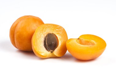 Beyaz arka plan üzerinde izole iki olgun taze kayısı. Yarısında bir kesik.