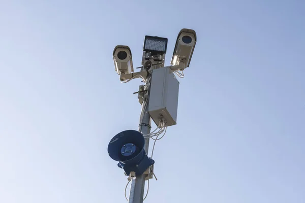 Toezicht op Cctv security camera's op de blauwe hemelachtergrond met megafoon — Stockfoto