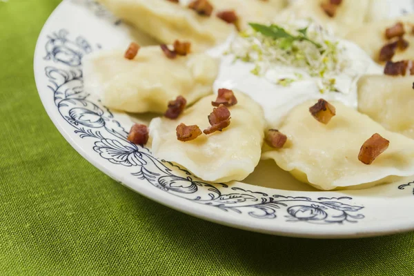 Bolinhos de massa cozidos com risca de porco de queijo e creme fraiche na mesa de madeira — Fotografia de Stock