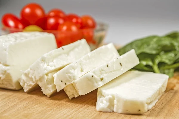 Queso Halloumi fresco en rodajas de Chipre en una tabla de madera —  Fotos de Stock