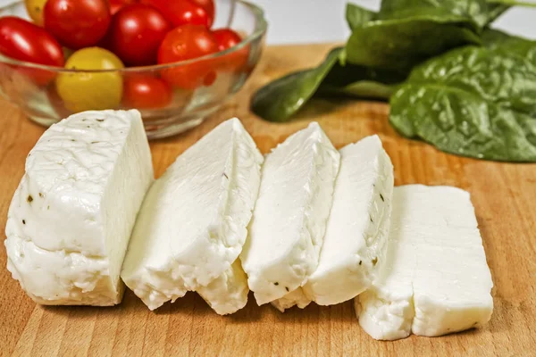 Queso Halloumi fresco en rodajas de Chipre en una tabla de madera —  Fotos de Stock