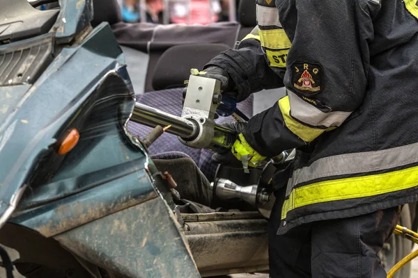 Bir otomatik araç kurtarma hidrolik güç kurtarma aracı ile çalışan itfaiyeciler