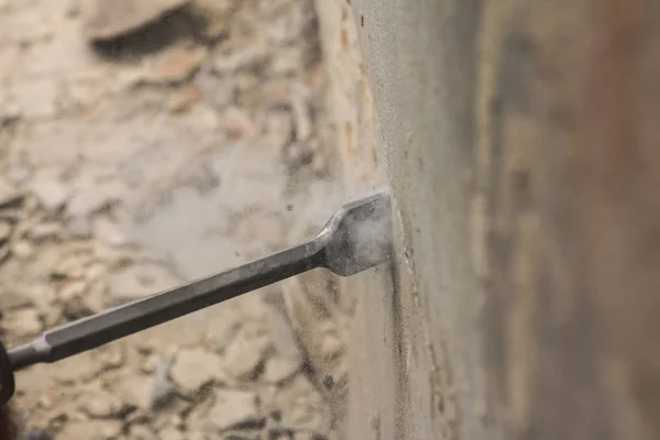 Arbeiter mit Elektrohammer putzt rote Ziegelwand — Stockfoto