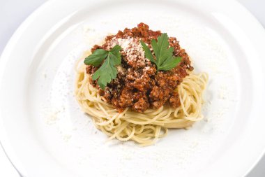 İtalyan spagetti makarna ile sığır eti ve domates sosu bolognese beyaz plaka üzerinde