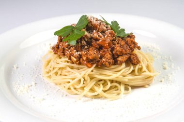 İtalyan spagetti makarna ile sığır eti ve domates sosu bolognese beyaz plaka üzerinde