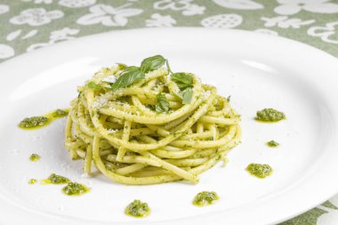 Beyaz tabak içinde yabani sarımsak pesto sos ve parmesan ile spagetti makarna Bucatini