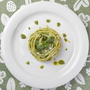 Spagetti makarna Bucatini pesto sos ve parmesan ile beyaz tabak içinde yabani sarımsak. Üstten Görünüm.