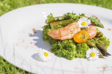 Karides, kuşkonmaz ve brokoli ile yenilebilir papatya çiçekler. Seçici odak. Açık fotoğraf.