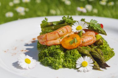 Karides, kuşkonmaz ve brokoli ile yenilebilir papatya çiçekler. Seçici odak. Açık fotoğraf.