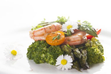 Karides, kuşkonmaz ve brokoli ile yenilebilir papatya çiçekler. Seçici odak.