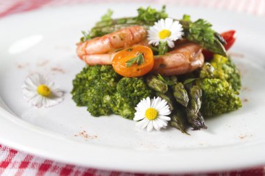 Karides, kuşkonmaz ve brokoli ile yenilebilir papatya çiçekler. Seçici odak.