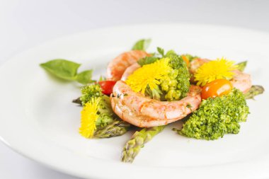 Karides, kuşkonmaz ve brokoli yenilebilir karahindiba çiçekli. Seçici odak.