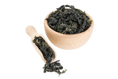 Tahta kasede kurumuş kombu yosunu ve beyaz arka planda izole edilmiş kepçe. 45 derece görüş. Baharatlar ve yemek malzemeleri.