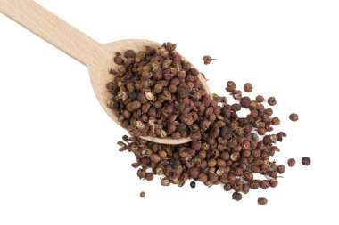 Beyaz arka planda izole edilmiş tahta kaşıkta sichuan biberi. yemek malzemesi.