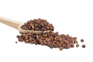 Beyaz arka planda izole edilmiş tahta kaşıkta sichuan biberi. yemek malzemesi.