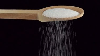 Bir kaşık öğütülmüş beyaz tuz, resimler ve yiyecek malzemeleri. Yavaş çekim.