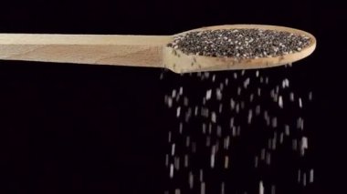 Bir kaşık chia çekirdeği. Baharatlar ve yemek malzemeleri. yavaş çekim