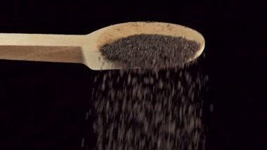 Bir kaşık öğütülmüş nigella. Baharatlar ve yemek malzemeleri. yavaş çekim