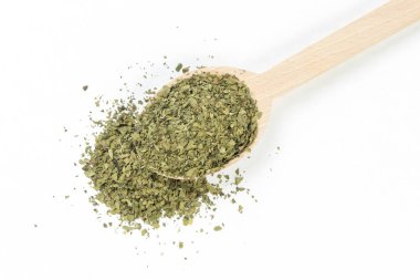 Beyaz arka planda izole edilmiş ahşap kaşıkta kurumuş aşk otu. Baharatlar ve yemek malzemeleri. Baharatlar ve yemek malzemeleri.